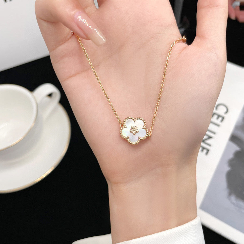 [Cyra] ARMBAND MIT GLÜCKSBRINGER AUS WEISSEM PERLMUTT UND PFLAUMENBLÜTE
