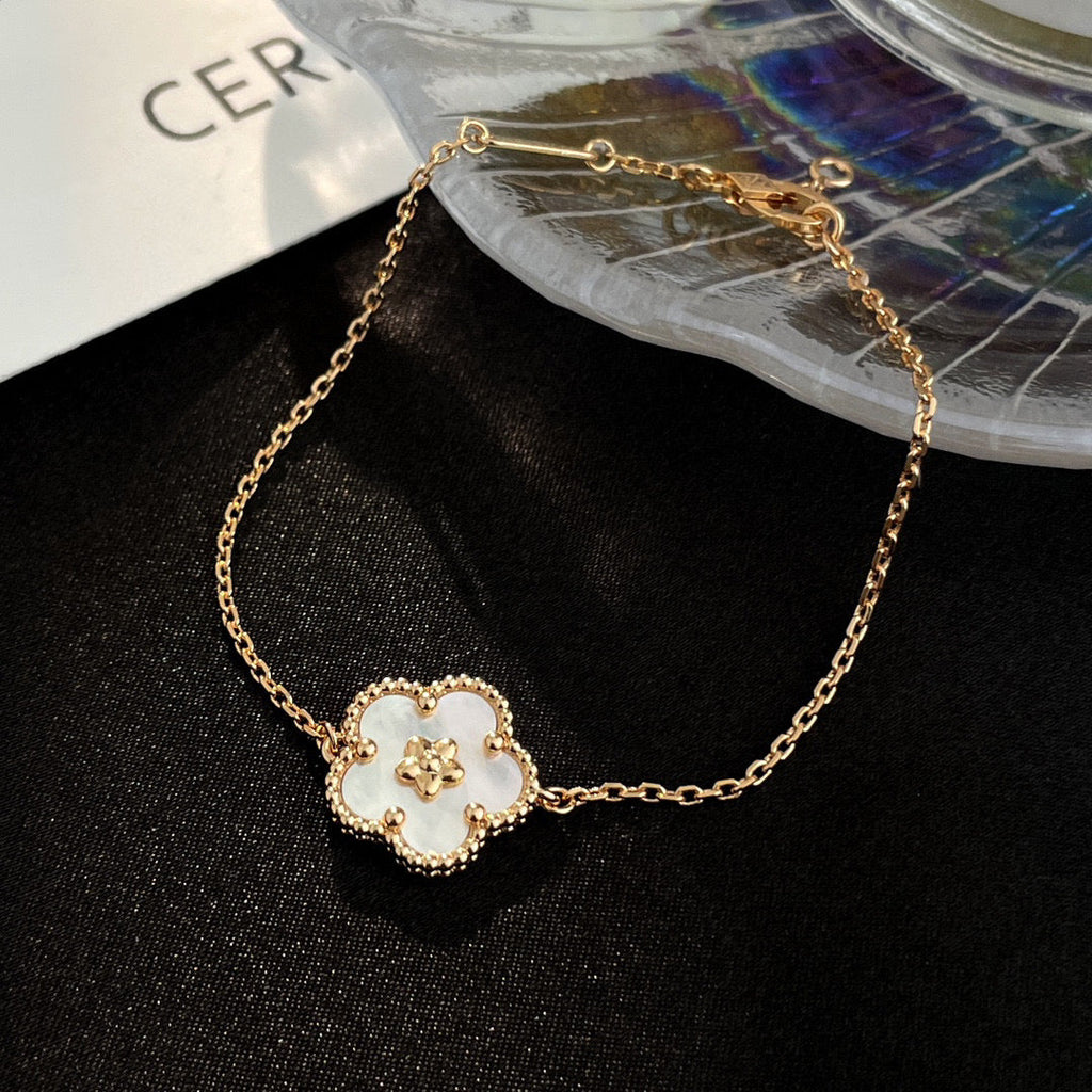[Cyra] ARMBAND MIT GLÜCKSBRINGER AUS WEISSEM PERLMUTT UND PFLAUMENBLÜTE